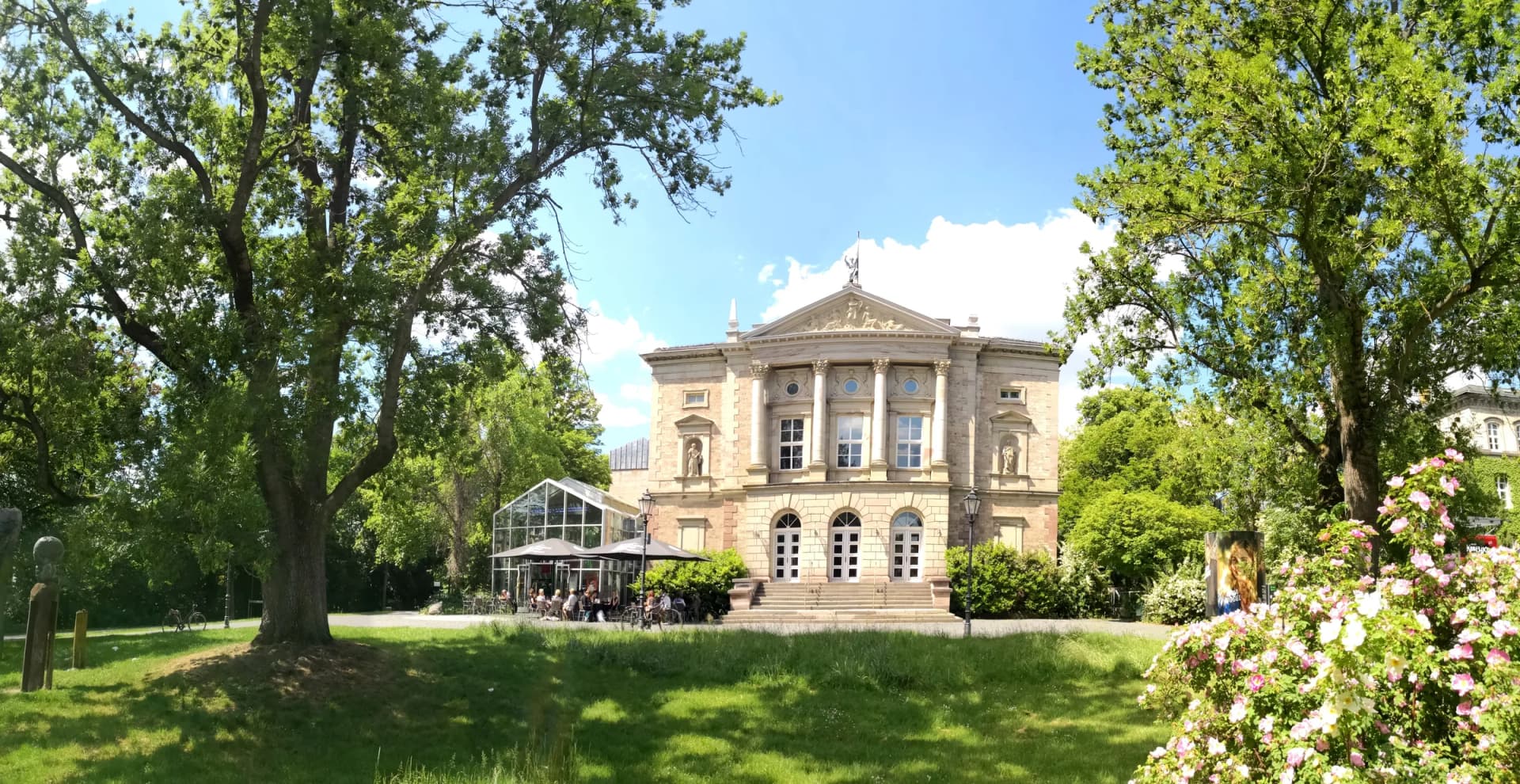 Deutsches Theater Göttingen zwischen Bäumen und Blumenbeeten