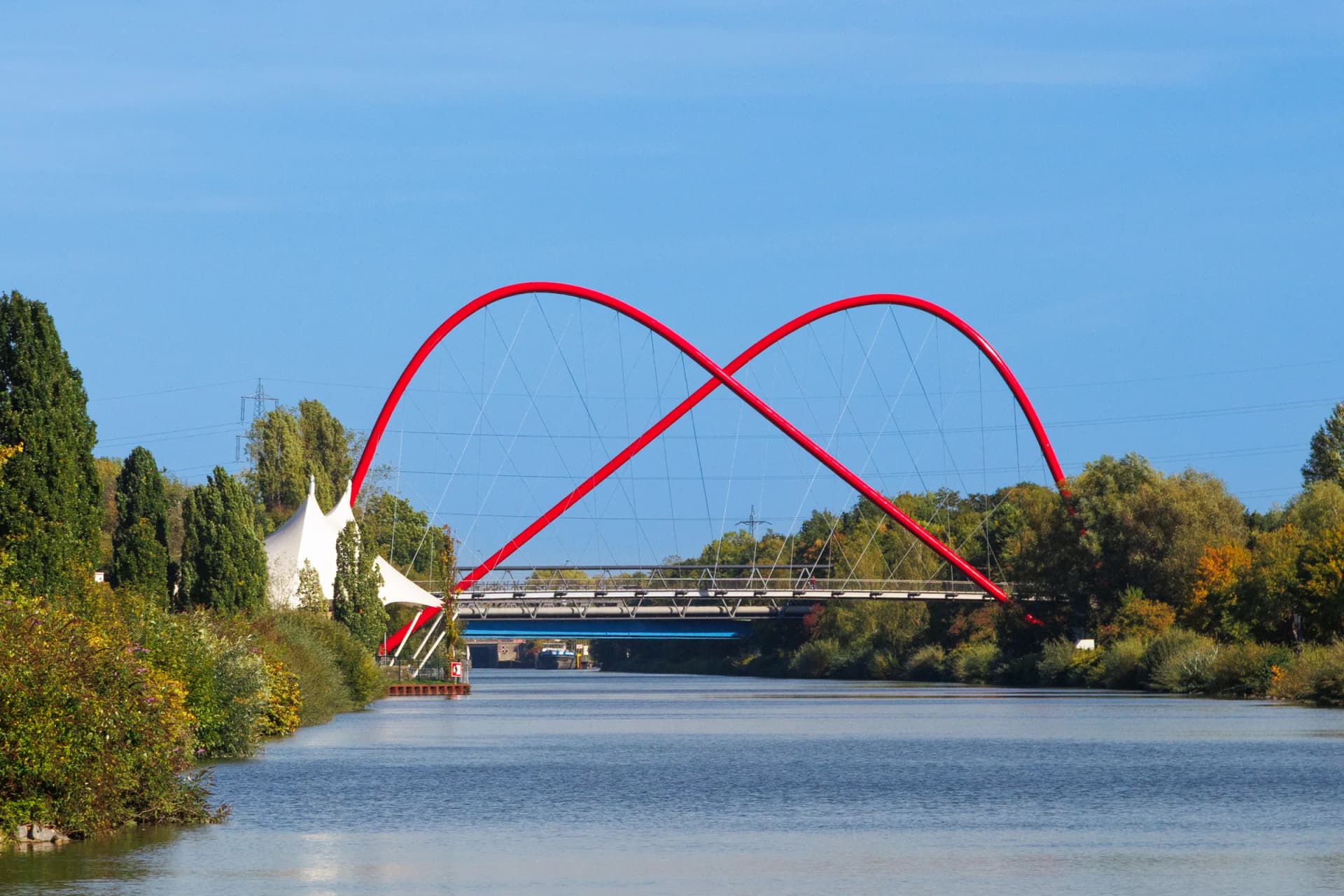 Rote Bogenbrücke im Nordsternpark in Gelsenkirchen über dem Wasser